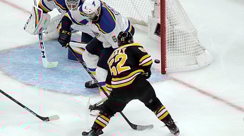 Boston Bruins’ Sean Kuraly (52) scores a goal past St. Louis Blues goaltender Jordan Binnington (50) and Joel Edmundson (6) during the third period in Game 1 of the NHL hockey Stanley Cup Final, Monday, May 27, 2019, in Boston. (AP Photo/Charles Krupa)
