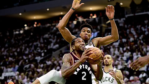 Toronto Raptors forward Kawhi Leonard (2) gets fouled by Milwaukee Bucks forward Giannis Antetokounmpo (34) during the second half in Game 1 of the NBA basketball playoffs Eastern Conference final in Milwaukee on Wednesday, May 15, 2019. (Frank Gunn/The Canadian Press via AP)