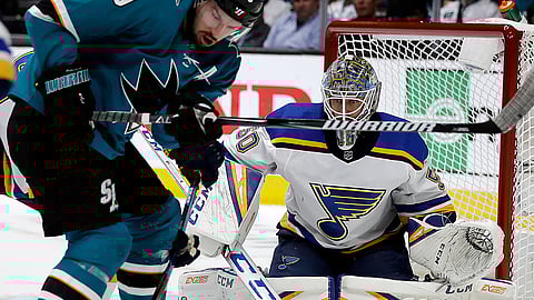 San Jose Sharks’ Logan Couture, left, moves the puck against St. Louis Blues goalie Jordan Binnington during the first period in Game 2 of the NHL hockey Stanley Cup Western Conference finals on May 13, 2019.