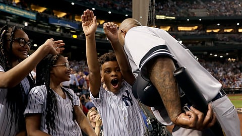 Yankees’ CC Sabathia greets his children after recording his 3,000th career strikeout on April 30 (Matt York)