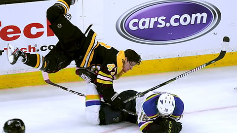 Boston Bruins’ Torey Krug, top, checks St. Louis Blues’ Robert Thomas to the ice during the third period in Game 1 of the NHL hockey Stanley Cup Final on May 27, 2019.