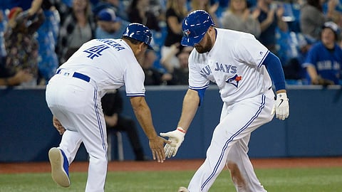 Toronto Blue Jays’ Rowdy Tellez, right, celebrates his home run with third base coach Luis Rivera during the 12th inning of a baseball game against the Boston Red Sox on May 22, 2019.