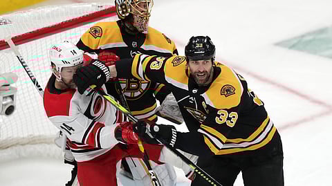 Boston Bruins’ Zdeno Chara (33) pushes Carolina Hurricanes’ Justin Williams (14) away from Bruins goalie Tuukka Rask during Game 2 of the NHL hockey Stanley Cup Eastern Conference final series on May 12, 2019