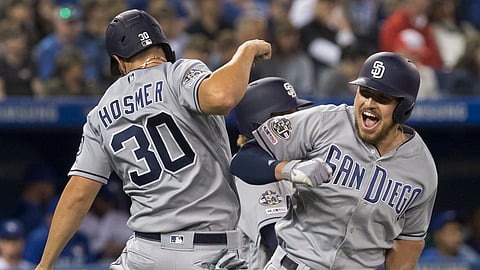 Padres’ Hunter Renfroe is greeted by Eric Hosmer after a three-run home run May 24 (Fred Thornhill/The Canadian Press)