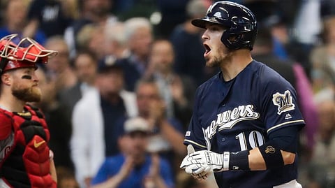 Brewers’ Yasmani Grandal passes Reds catch Tucker Barnhart after his two-run home run in the sixth inning May 22 (Morry Gash)