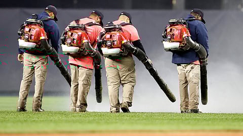 Groundskeepers try to dry the Yankee Stadium field before the game with the Orioles on May 13 was postponed (Kathy Willens)