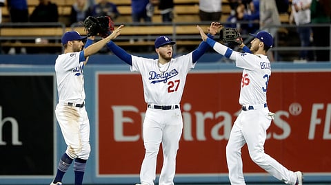From left, Los Angeles Dodgers’ Chris Taylor, Alex Verdugo and Cody Bellinger celebrate after a win over the Atlanta Braves on May 8, 2019.