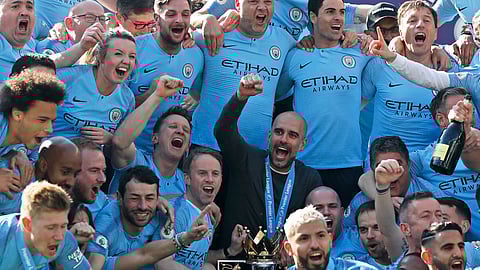 Manchester City coach Pep Guardiola, center, celebrates with players and staff after the English Premier League soccer match between Brighton and Manchester City at the AMEX Stadium in Brighton, England, Sunday, May 12, 2019. Manchester City defeated Brighton 4-1 to win the championship. (AP Photo/Frank Augstein)