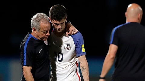 United States’ Christian Pulisic (10) is comforted by assistant coach Dave Sarachan after losing 2-1 against Trinidad and Tobago during a 2018 World Cup qualifying soccer match in October of 2017 (Rebecca Blackwell, File)