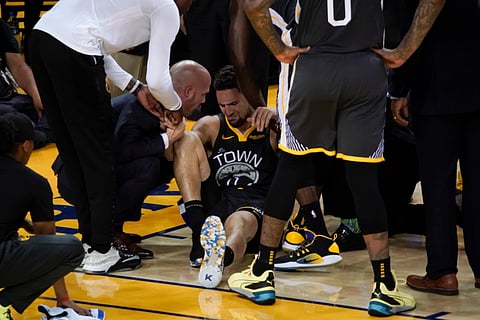 Golden State Warriors guard Klay Thompson, center, is helped up after being injured during the second half of Game 6 of basketball’s NBA Finals against the Toronto Raptors in Oakland, Calif., Thursday, June 13, 2019. (AP Photo/Tony Avelar)