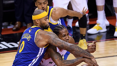 Golden State Warriors’ DeMarcus Cousins ties up Toronto Raptors’ Kawhi Leonard during the second half of Game 2 of basketball’s NBA Finals on June 2, 2019.