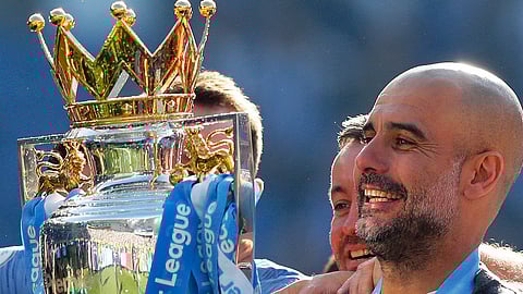 Manchester City coach Pep Guardiola lifts the English Premier League trophy on May 12 (Frank Augstein)