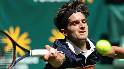 Pierre-Hugues Herbert returns the ball to Gael Monfils during their first round match at the ATP tennis tournament in Halle Westphalia, Germany, on June 17 (Friso Gentsch/dpa)