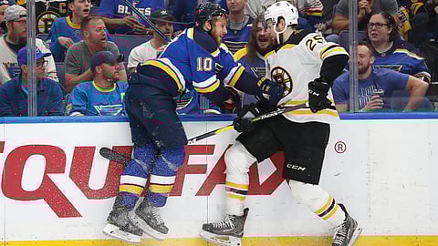 Blues center Brayden Schenn (10) and Bruins defenseman Brandon Carlo  battle along the board in Game 4 (Jeff Roberson)