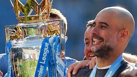 In this Sunday, May 12, 2019 file photo, Manchester City coach Pep Guardiola lifts the English Premier League trophy after the English Premier League soccer match between Brighton and Manchester City at the AMEX Stadium in Brighton, England.