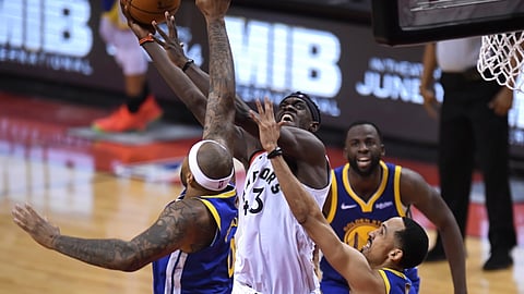 Toronto Raptors forward Pascal Siakam scores as Golden State Warriors center DeMarcus Cousins and guard Shaun Livingston, right, defend during the second half of Game 1 of basketball’s NBA Finals on May 30, 2019.
