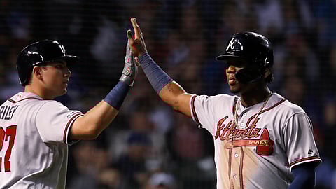 Braves’ Ronald Acuna Jr. (right) high fives  with Austin Riley after scoring a run against the Cubs on June 24 (Jim Young)