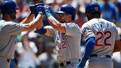 Cubs’ Cole Hamels (left) congratulates Kyle Schwarber as he crosses home plate after connecting for a three-run home run as Jason Heyward looks on in the second inning on June 12 (David Zalubowski)