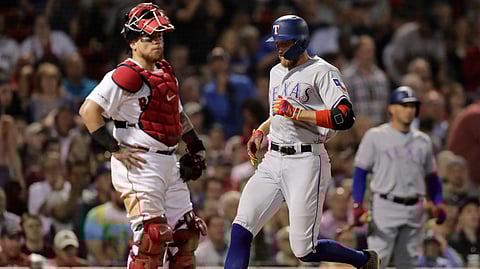 Texas Rangers’ Hunter Pence, right, crosses home plate in front of Boston Red Sox catcher Christian Vazquez, left, while scoring on his inside the park home run in the sixth inning of a baseball game at Fenway Park on June 11, 2019.