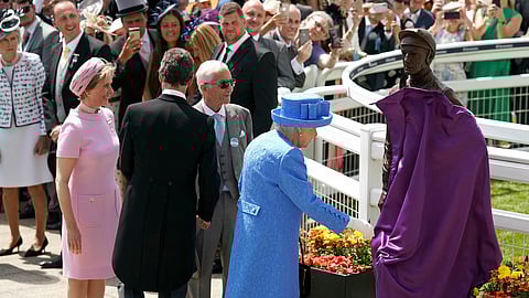 Britain’s Queen Elizabeth II unveils a statue of famed jockey Lester Piggott, as Lester Piggott, front 3rd left, looks on with Sophie Countess of Wessex, left, during Derby Day at Epsom Racecourse, England, Saturday June 1, 2019. (John Walton/PA via AP)