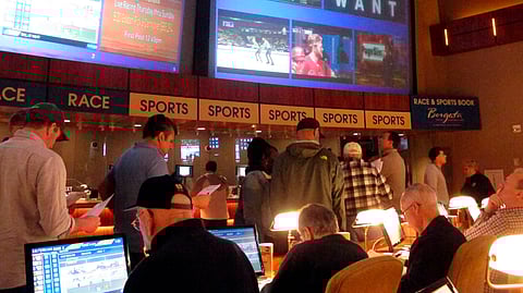 FILE - In this March 21, 2019, file photo, gamblers line up to place bets on the NCAA men’s college basketball tournament at the Borgata casino in Atlantic City N.J.  (AP Photo/Wayne Parry, File)