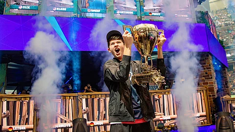 In this July 28, 2019 photo, Kyle Giersdorf celebrates as he holds up the trophy after winning the Fortnite World Cup solo finals in New York. Giersdorf, of Pottsgrove, Pa. who goes by the name "Bugha" when competing, racked up the most points and won $3 million as the first Fortnite World Cup solo champion.