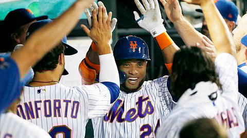 Teammates congratulate New York Mets' Robinson Cano, center, after he hit a solo home run during the fourth inning of a baseball game against the San Diego Padres, Tuesday, July 23, 2019, in New York. (AP Photo/Kathy Willens)