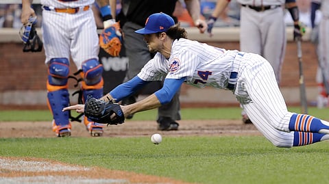 Mets pitcher Chis Maza dives to catch a foul ball by Braves’ Tyler Flowers on June 29 (Frank Franklin II)
