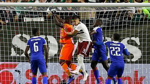 Haiti goalkeeper Jhony Placide, second from left, makes a save as he collides with Mexico defender Carlos Salcedo (3) as Haiti defender Jems Geffrard (6), Haiti defender Alex Christian (22) and Haiti defender Andrew Jean-Baptiste, second from right, look on during the first half of a CONCACAF Gold Cup soccer match Tuesday, July 2, 2019, in Glendale, Ariz. (AP Photo/Ross D. Franklin)