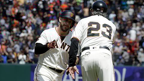 Giants’ Evan Longoria (left) is greeted by third base coach Ron Wotus after hitting a solo home run against the Cardinals on July 7 (Jeff Chiu)