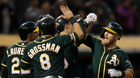 Athletics’ Chris Herrmann (right) is greeted by teammates after hitting a grand slam off  Twins’ Jake Odorizzi in the fourth inning on July 2 (Ben Margot)