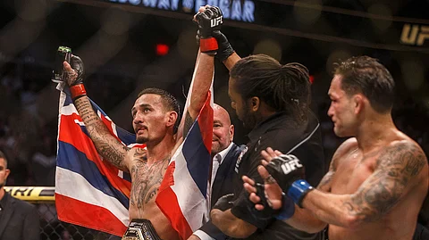 Max Holloway celebrates the win over Frankie Edgar during a mixed martial arts bout at UFC 240, in Edmonton, Alberta, Saturday, July 27, 2019. (Jason Franson/The Canadian Press via AP)