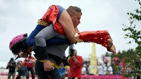People take part in the wife carrying race, a 278-yard obstacle course, during the 24th world championships in Sonkajarvi, Finland, Saturday, July 6, 2019. Despite the event’s name couples don’t have to be married, and organizers say male contestants could “steal a neighbor’s wife” if they didn’t have a female companion. (AP Photo/David Keyton)