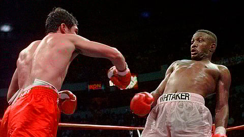 FILE - In this April 12, 1997, file photo, Pernell Whitaker, right, leans away from a punch by Oscar De La Hoya during their WBC Welterweight Championship fight at Thomas & Mack Center in Las Vegas. De La Hoya won by unanimous decision. Former boxing champion Pernell Whitaker has died after he was hit by a car in Virginia. He was 55. Police in Virginia Beach on Monday say Whitaker was a pedestrian when struck by the car Sunday night, July 14, 2019. The driver remained on the scene, where Whitaker was pronounced dead. (AP Photo/Eric Draper, File)