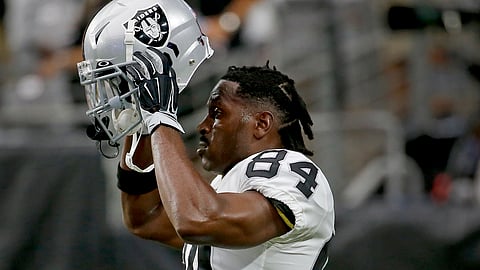 In this Aug. 15, 2019, file photo, Oakland Raiders wide receiver Antonio Brown (84) puts on his helmet prior to the team's NFL football game against the Arizona Cardinals in Glendale, Arizona.