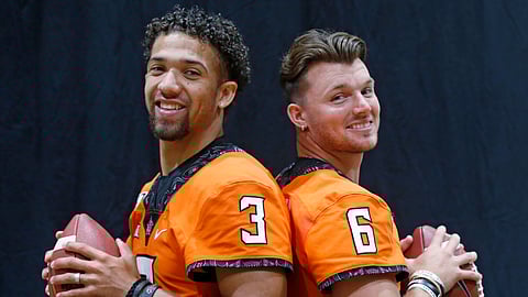 FILE - In this Saturday, Aug. 3, 2019, file photo, Oklahoma State quarterbacks Spencer Sanders, left, and Dru Brown pose for a photo during the NCAA college football team's media day in Stillwater Okla. Oklahoma State hasn’t named a starting quarterback yet for its season opener next Friday night at Oregon State, as coach Mike Gundy continues to evaluate redshirt freshman Spencer Sanders and Hawaii grad transfer Dru Brown for the job. At this point, it seems likely that both will see action. (AP Photo/Sue Ogrocki, File)