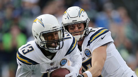 In this Nov. 4, 2018, file photo, Los Angeles Chargers quarterback Philip Rivers, right, hands off to Keenan Allen during the first half of the team's NFL football game against the Seattle Seahawks in Seattle.