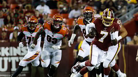 Washington Redskins quarterback Dwayne Haskins (7) scrambles away from Cincinnati Bengals defensive end Jordan Willis (75), defensive tackle Andrew Brown (93) and defensive tackle Renell Wren (95) during the first half of an NFL preseason football game Thursday, Aug. 15, 2019, in Landover, Md.