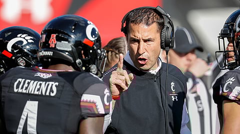 FILE - In this Saturday, Nov. 3, 2018, file photo, Cincinnati head coach Luke Fickell, right, speaks with linebacker Malik Clements (4) before an NCAA college football game against Navy in Cincinnati. Nobody saw Cincinnati coming in the American Athletic Conference last year. Not even Luke Fickell, who guided the team to a seven-victory improvement in his second season as Bearcats coach. Best to expect the unexpected in the AAC. The league has been fertile ground for fast turnarounds since it rose from the ashes of the old Big East in 2013. (AP Photo/John Minchillo, File)