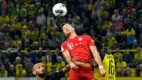 Bayern's Robert Lewandowski, center, jumps for the ball with Dortmund's Omer Toprak, left, and Dortmund's Manuel Akanji during the German Supercup final soccer match between Borussia Dortmund and Bayern Munich in Dortmund, Germany, Saturday, Aug. 3, 2019. (AP Photo/Martin Meissner)