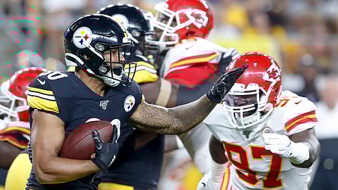Pittsburgh Steelers running back James Conner (30) runs away from Kansas City Chiefs defensive end Alex Okafor (97) in the first half of a preseason NFL football game, Saturday, Aug. 17, 2019, in Pittsburgh.
