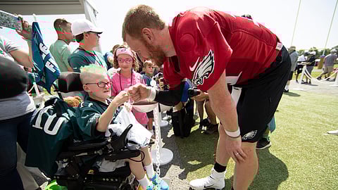 Philadelphia Eagles quarterback Carson Wentz bumps fists with eleven-year-old Giovanni Hamilton who is attending the practice as part of a wish granted by Bianca's Kids at the NFL football team's training camp in Philadelphia, Friday, July 26, 2019.