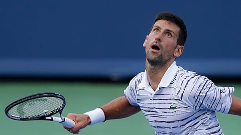 Novak Djokovic, of Serbia, looks to return the ball to Daniil Medvedev, of Russia, during the Western & Southern Open tennis tournament Saturday, Aug. 17, 2019, in Mason, Ohio. (AP Photo/John Minchillo)