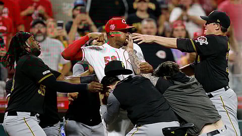 Cincinnati Reds relief pitcher Amir Garrett (50) throws punches as he is held back by a number of Pittsburgh Pirates players during a bench clearing brawl between the Reds and the Pirates at Great American Ball Park on Tuesday, July 30, 2019. (Sam Greene/The Cincinnati Enquirer via AP)