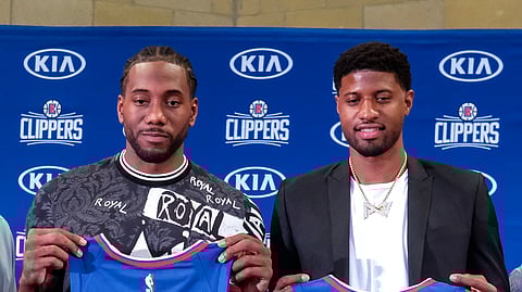 Kawhi Leonard, left, and Paul George pose with their new team jerseys during a press conference in Los Angeles on July 24, 2019.