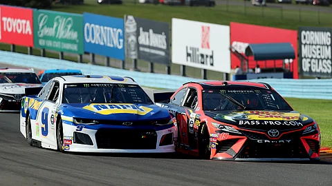 Chase Elliott (9) holds off an attempt to pass by Martin Truex, Jr., after a restart following a yellow caution flag during a NASCAR Cup series auto race at Watkins Glen International, Sunday, Aug. 4, 2019, in Watkins Glen, N.Y. (AP Photo/John Munson)