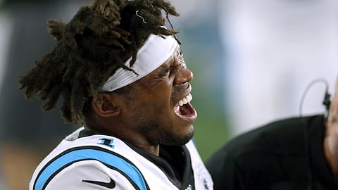 Carolina Panthers quarterback Cam Newton grimaces as he receives attention on the sideline after an injury in the first half of an NFL preseason football game against the New England Patriots, Thursday, Aug. 22, 2019, in Foxborough, Mass.