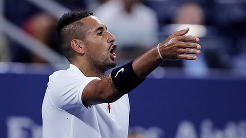 Nick Kyrgios, of Australia, points out distractions in the crowd during his match against Steve Johnson, of the United States, during the first round of the U.S. Open tennis tournament in New York, early Wednesday, Aug. 28, 2019. (AP Photo/Charles Krupa)