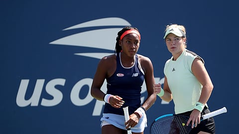 Coco Gauff, left, and Catherine McNally, both of the United States, talk during a first round doubles match against Julia Goerges, of Germany, and Katerina Siniakova, of the Czech Republic, at the US Open tennis championships Friday, Aug. 30, 2019, in New York. (AP Photo/Kevin Hagen)