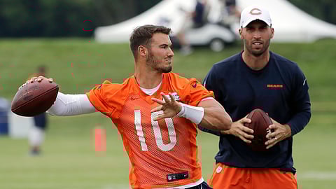 In this July 26, 2019 photo, Chicago Bears quarterback Mitchell Trubisky, left, throws a ball as quarterbacks coach Dave Ragone looks on during an NFL football training camp in Bourbonnais, Ill.